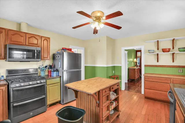 a kitchen with a stove a refrigerator and a microwave