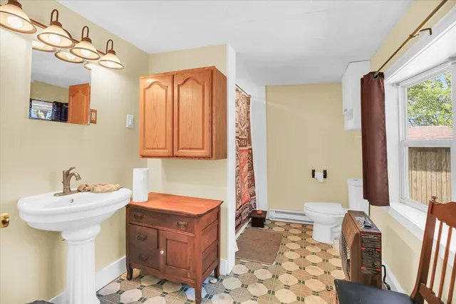 a bathroom with a sink a toilet and mirror
