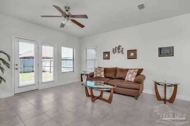 a living room with furniture and a floor to ceiling window