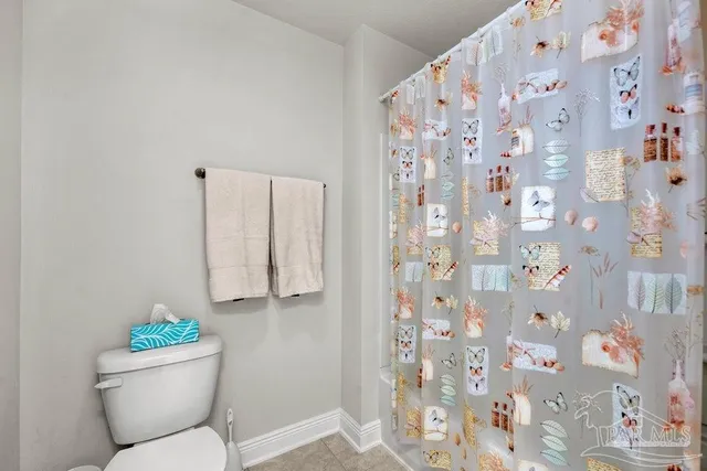 a bathroom with a toilet and a shower curtain