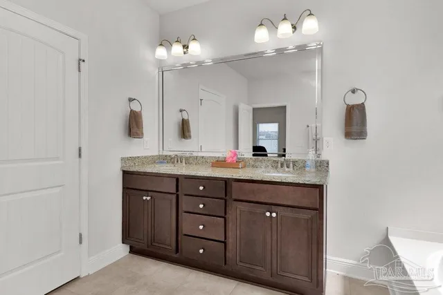 a bathroom with a granite countertop sink a mirror and a light fixture