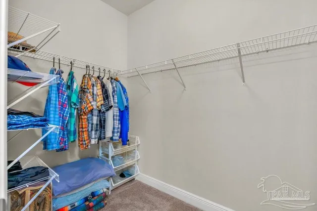a view of walk in closet with clothes and shoes