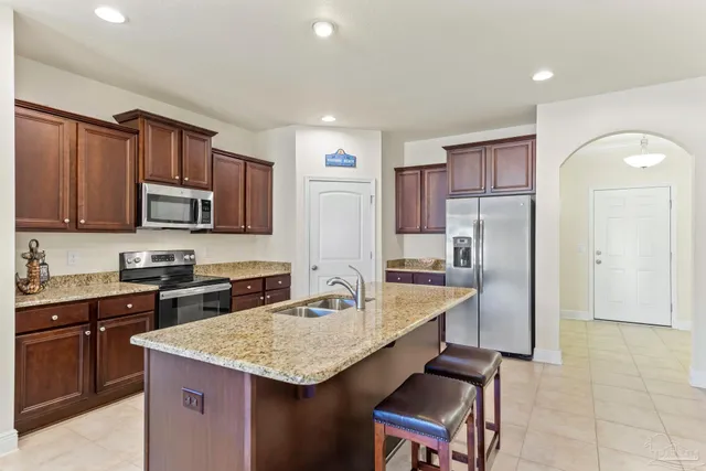 a kitchen with granite countertop a sink stove and refrigerator