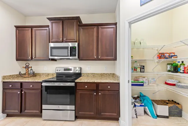 a kitchen with kitchen island granite countertop a sink stove and microwave