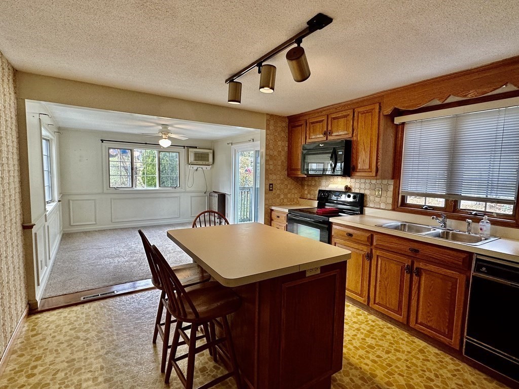 4 Manwell Road Chelmsford, MA 01824 - Photo 5 of 22 a kitchen with stainless steel appliances granite countertop a stove a sink dishwasher and a refrigerator with wooden cabinets
