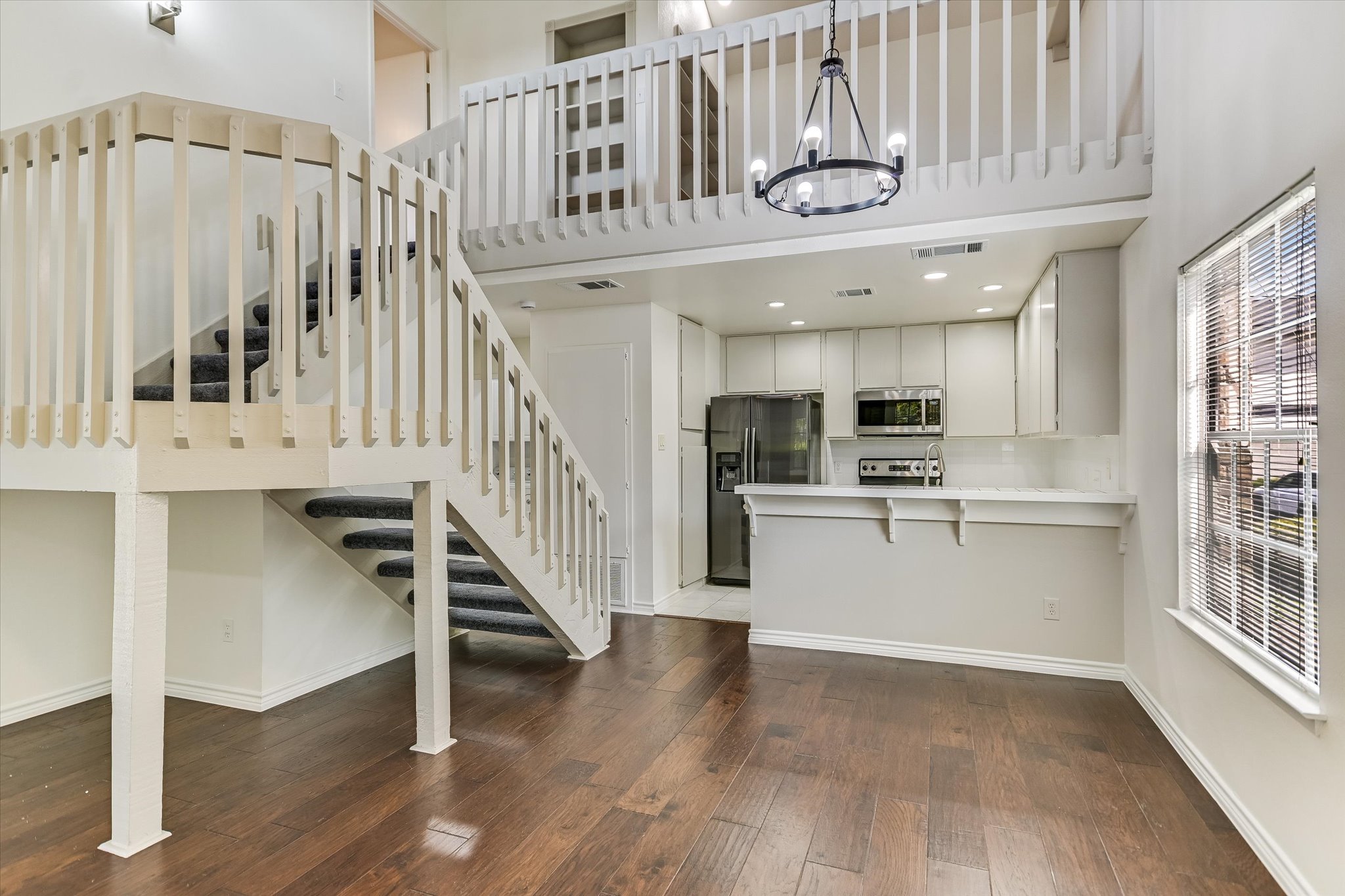 1748 Ohlen Road, Unit 37 Austin, TX 78757 - Photo 6 of 16 Rich hardwood flooring anchors the soaring multi-level living area overlooked by an open loft upstairs.