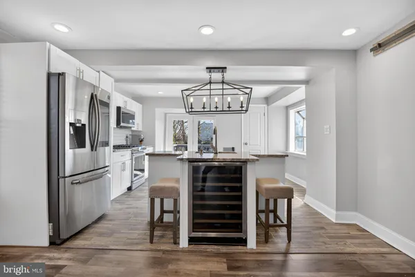 a kitchen with stainless steel appliances kitchen island granite countertop a refrigerator and microwave