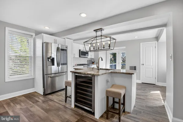 a open kitchen with stainless steel appliances granite countertop a stove and a refrigerator