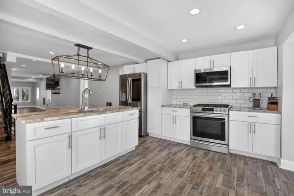 a large kitchen with a sink and stainless steel appliances