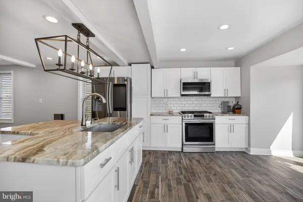 a large kitchen with stainless steel appliances granite countertop a sink and cabinets