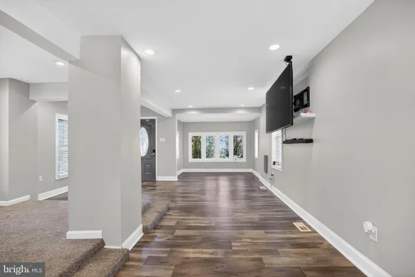 a view of a hallway with wooden floor and staircase