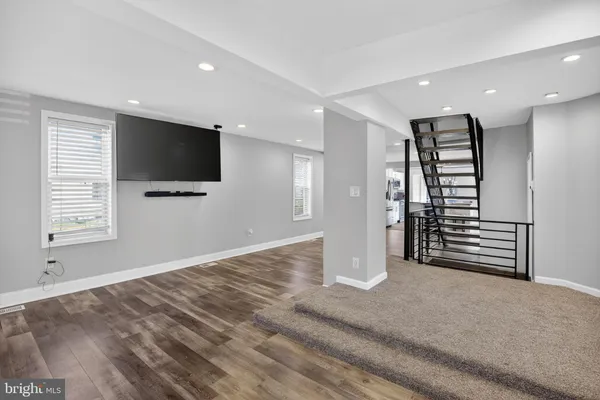 a view of a livingroom with wooden floor and a flat screen tv