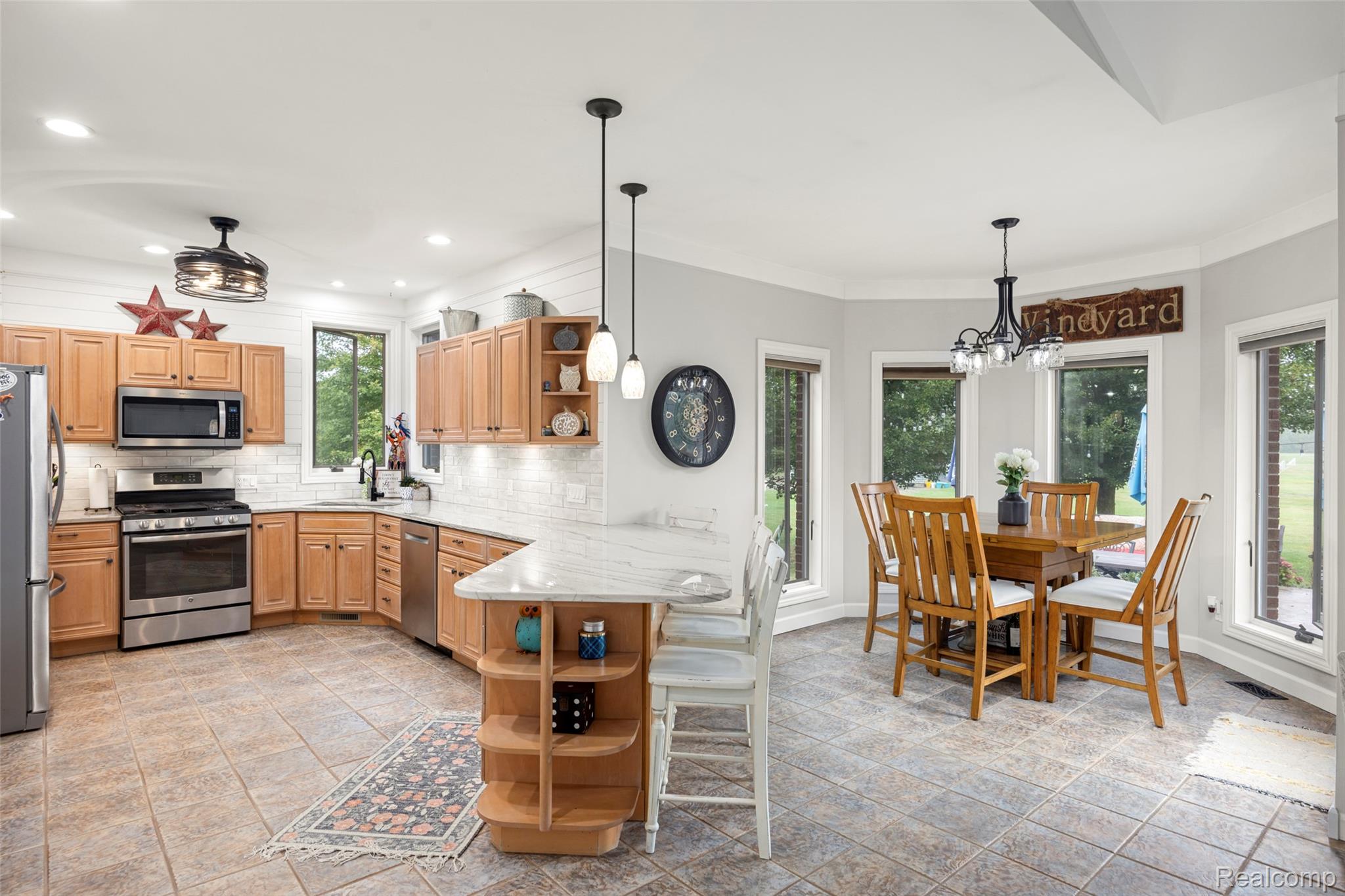 7030 Marsh Road Marine City, MI 48039 - Photo 11 of 47 Kitchen with open shelves, a peninsula, stainless steel appliances, a breakfast bar, and backsplash
