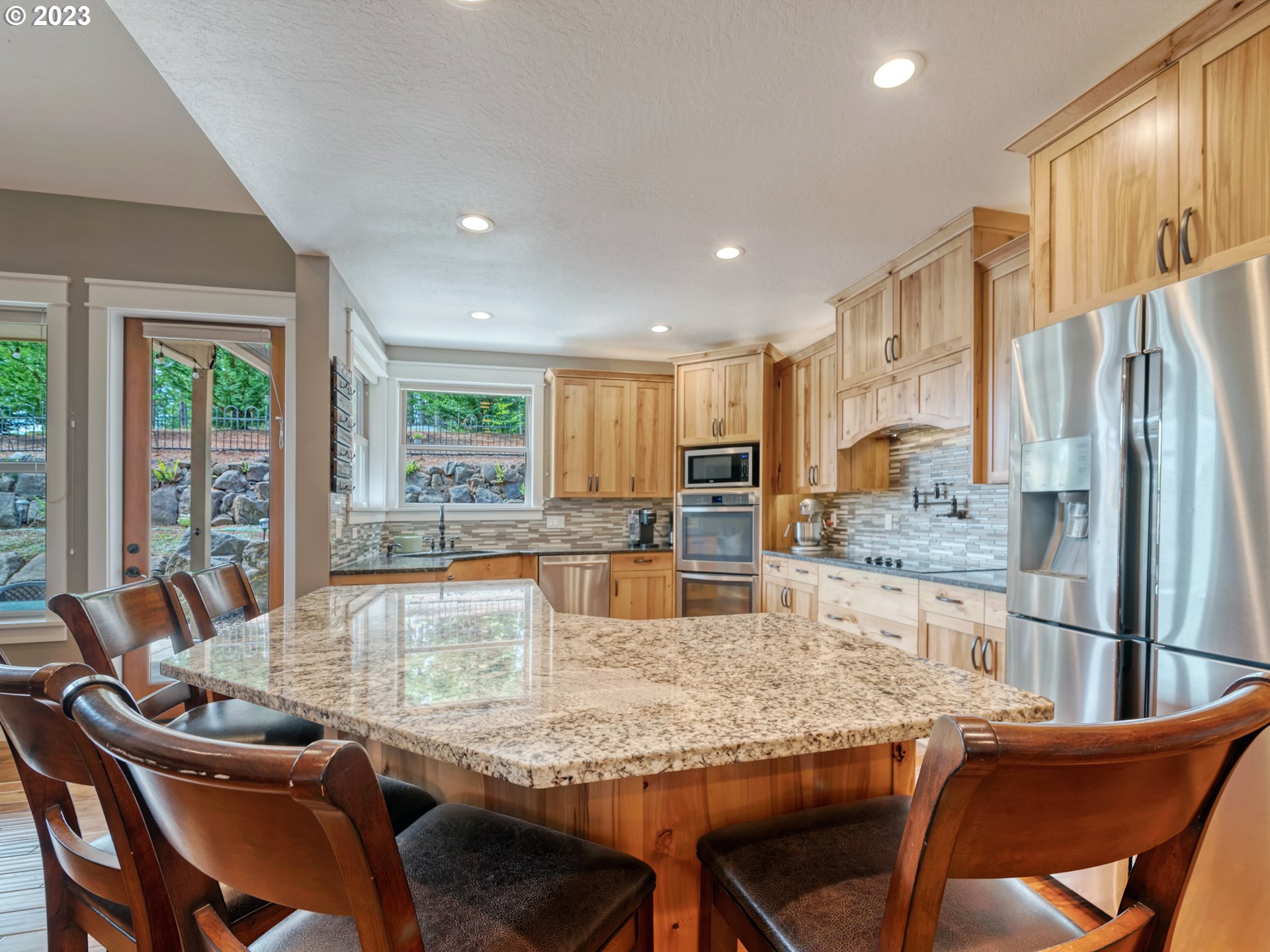 27876 Lady Slipper Loop Eugene, OR 97405 - Photo 38 of 45 a kitchen with granite countertop kitchen island stainless steel appliances a table and chairs
