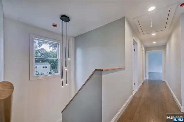 a view of hallway with stairs and wooden floor