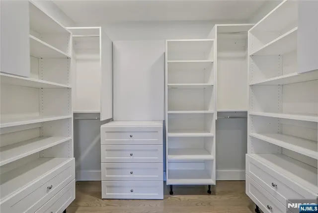 a view of walk in closet with empty racks