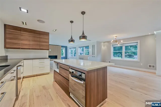 an open kitchen with granite countertop a stove and a sink