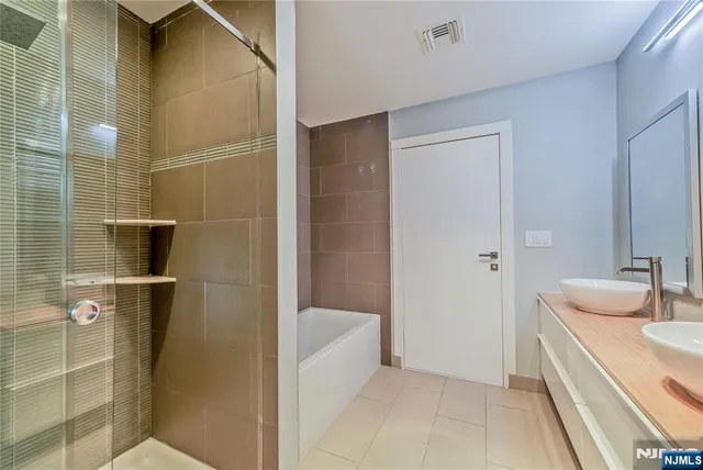 a bathroom with a tub sink and mirror