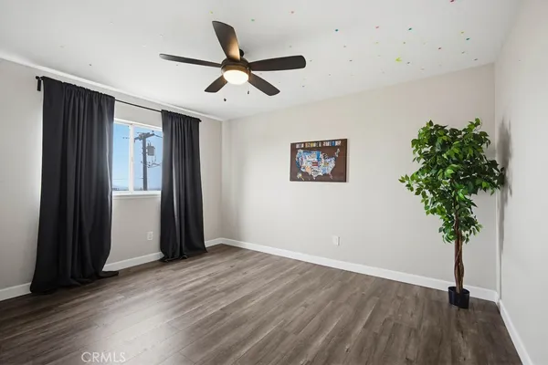a view of a livingroom with a potted plant wooden floor and a ceiling fan