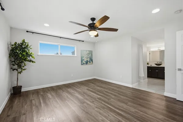 a view of a big room with wooden floor and a chandelier fan