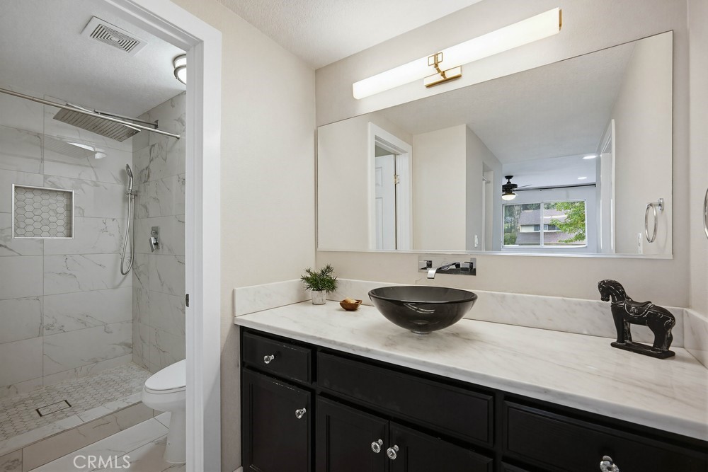 2256 Kentwood Drive Riverside, CA 92507 - Photo 21 of 26 a bathroom with a double vanity sink and mirror with shower