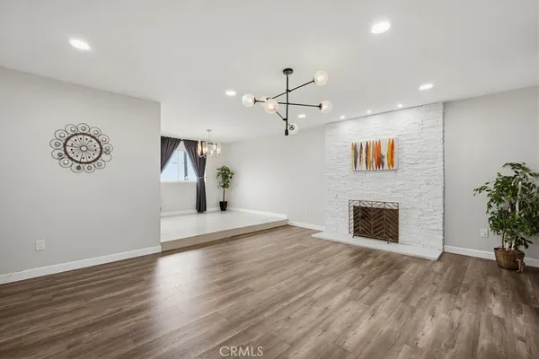 a view of a livingroom with a fireplace and wooden floor