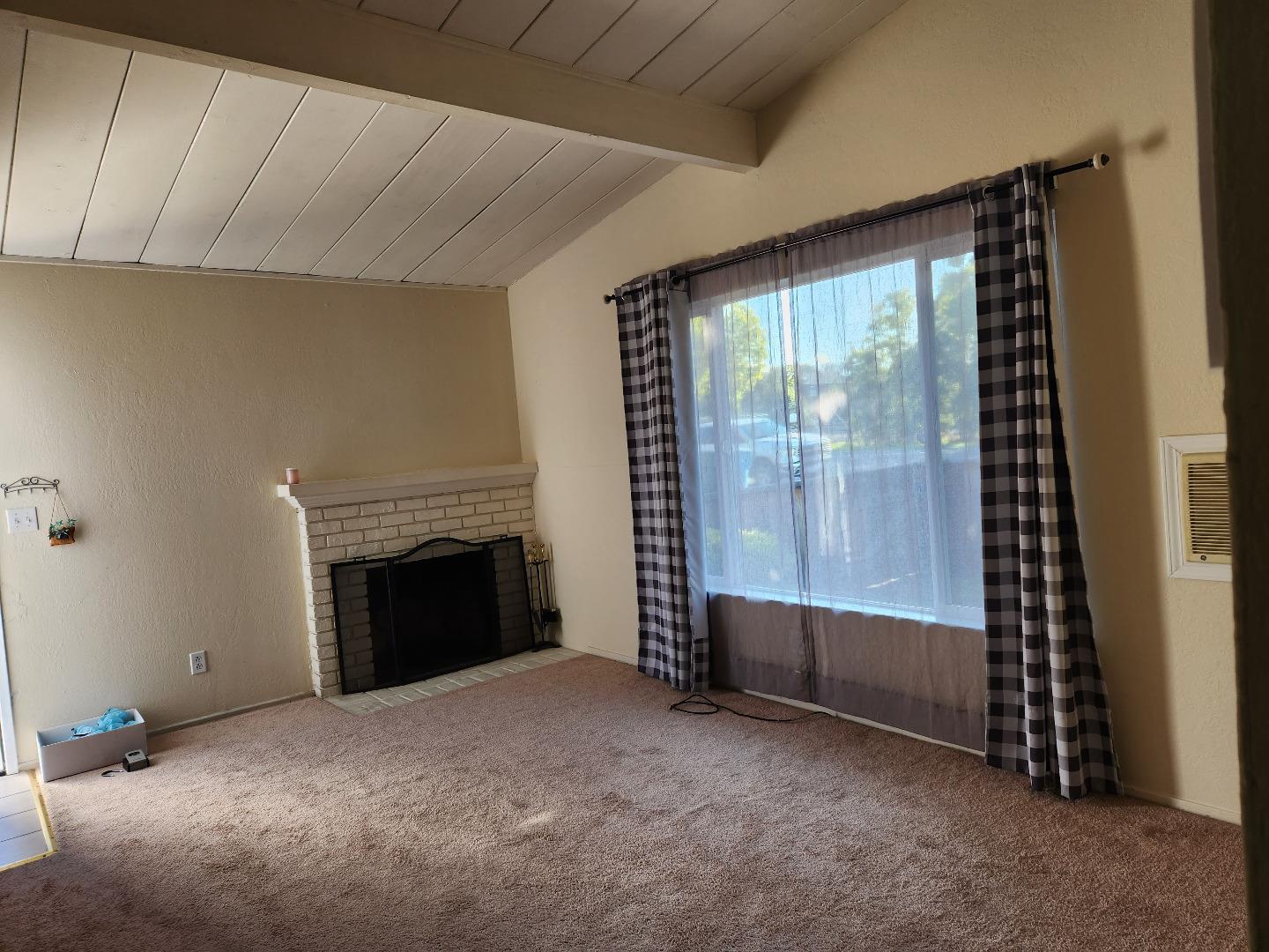 a view of empty room with fireplace and window