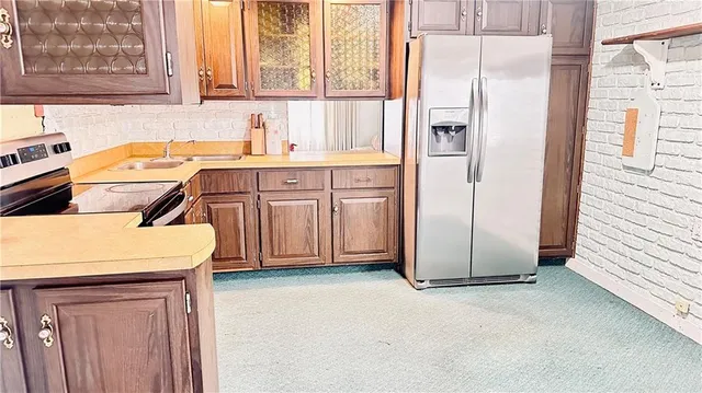a kitchen with a refrigerator sink and cabinets
