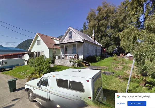 a view of a house with backyard sitting area and garden
