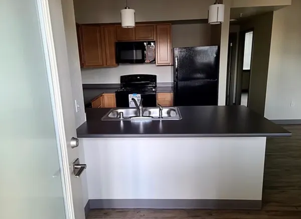 a kitchen with stainless steel appliances granite countertop a refrigerator a stove and a sink