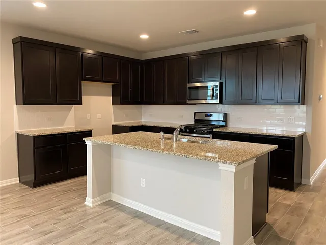a kitchen with stainless steel appliances wooden cabinets and a sink