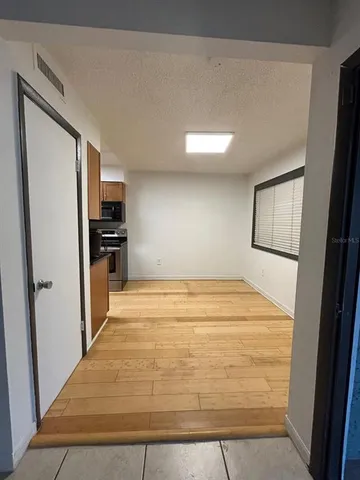 a view of a hallway with wooden floor and glass door