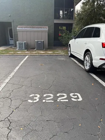 a view of a house with a backyard and parking