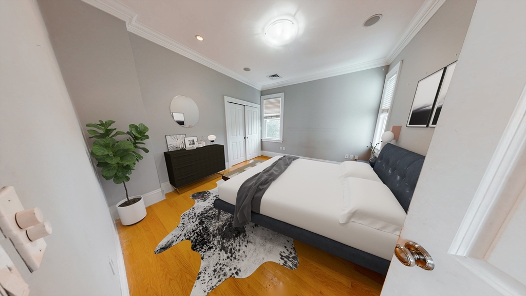 30-32 Ward Street, Unit 2 Boston, MA 02127 - Photo 8 of 14 a bedroom with a bed dresser flowerpot and wooden floor