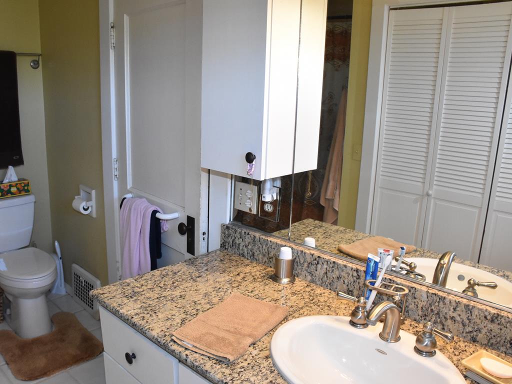 655 Chestnut Street Meadville, PA 16335 - Photo 32 of 43 a bathroom with a granite countertop sink a toilet and a mirror