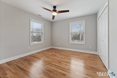 a bedroom with a bed and wooden floor