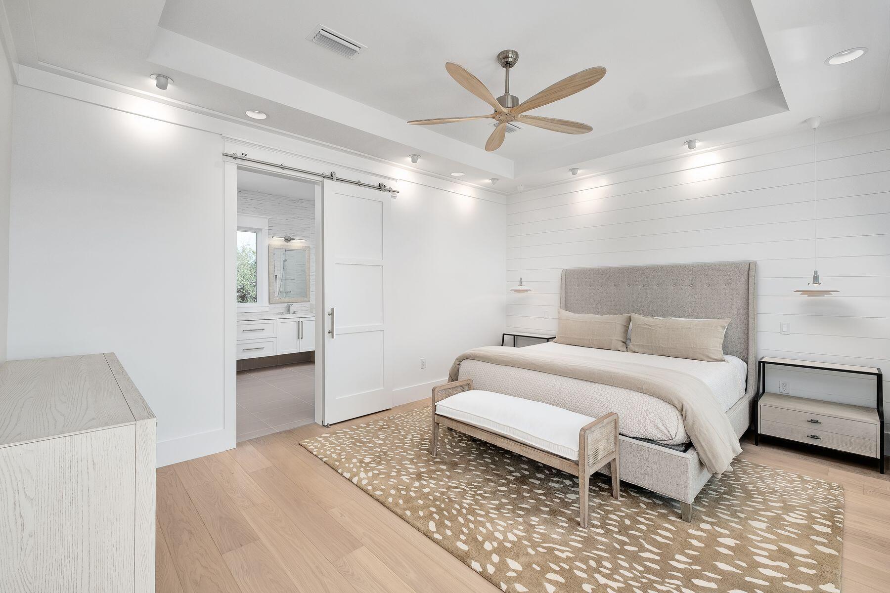 56 Pelican Glide Lane Seacrest, FL 32461 - Photo 24 of 55 a spacious bedroom with a bed and a chandelier