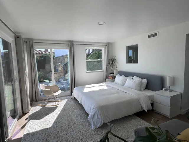 a bedroom with a bed and a large window