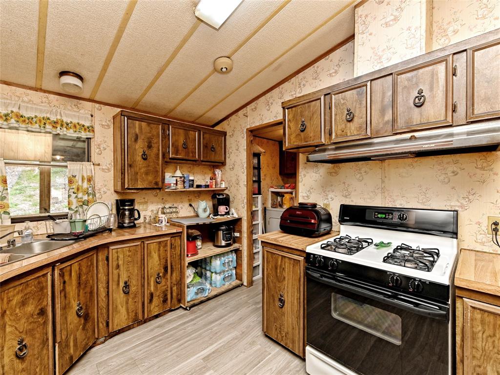 148 River Road Liberty Hill, TX 78642 - Photo 12 of 22 a kitchen with stainless steel appliances granite countertop a stove and a sink