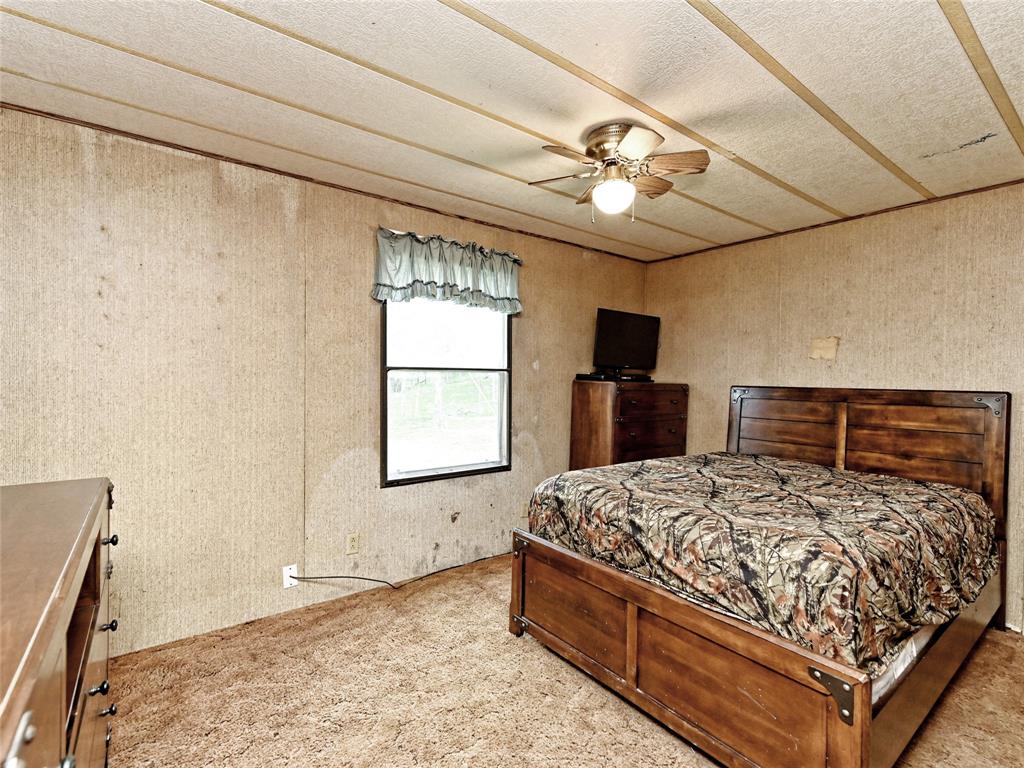 148 River Road Liberty Hill, TX 78642 - Photo 15 of 22 a bedroom with a bed and a chandelier