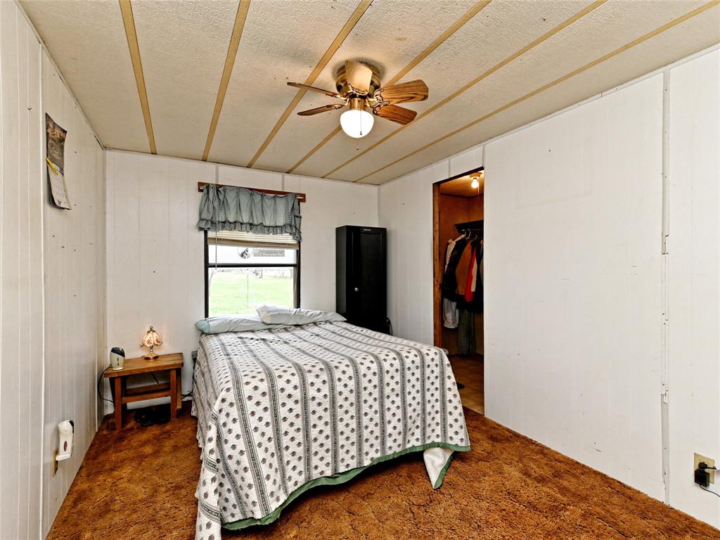 148 River Road Liberty Hill, TX 78642 - Photo 21 of 22 a bedroom with a bed and a chandelier