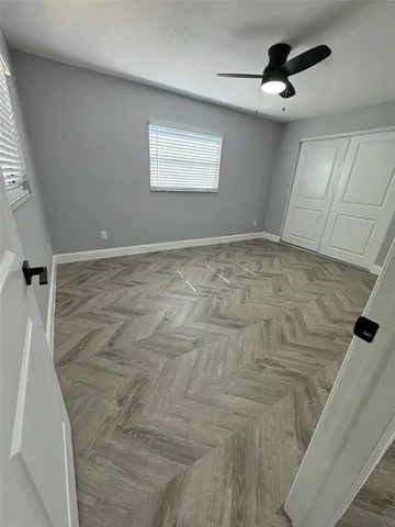 a view of an empty room with closet and a window