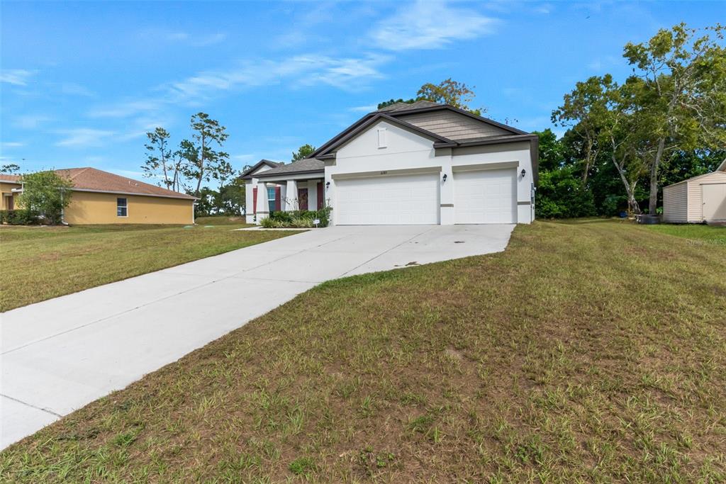 6283 Grapewood Road Spring Hill, FL 34609 - Photo 4 of 41 a front view of a house with a yard and garage
