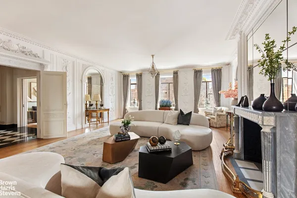 a living room with furniture a large window and a fireplace