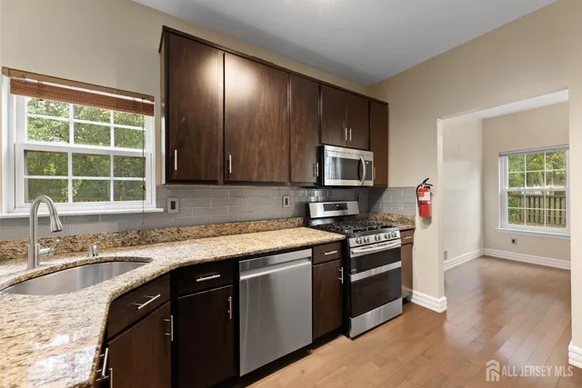 a kitchen with stainless steel appliances granite countertop a stove and a microwave
