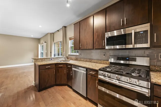 a kitchen with stainless steel appliances granite countertop a refrigerator and a stove
