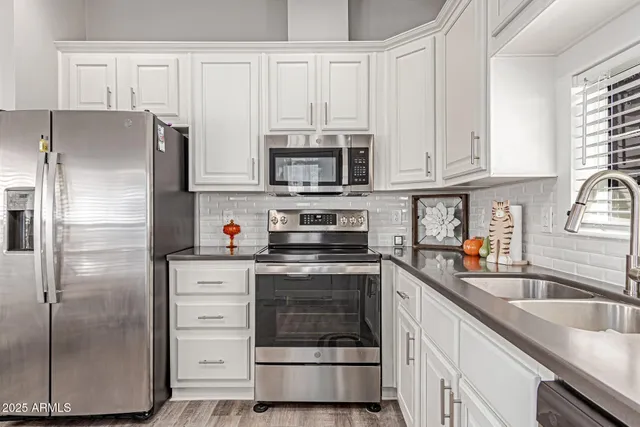 a kitchen with stainless steel appliances granite countertop a refrigerator stove and sink