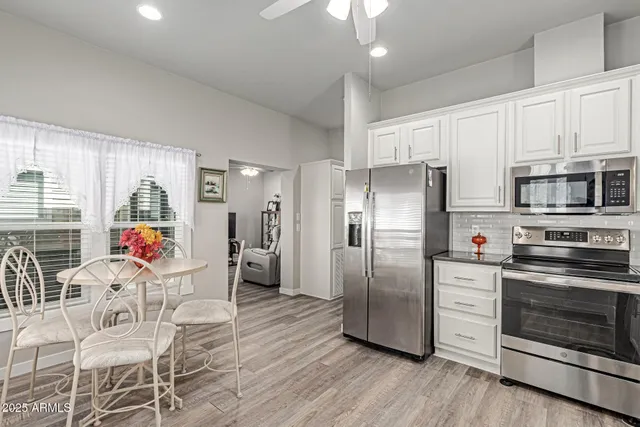 a kitchen with stainless steel appliances granite countertop a refrigerator microwave and wooden floor