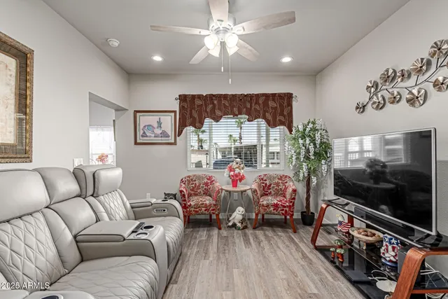 a living room with furniture a flat screen tv and a floor to ceiling window