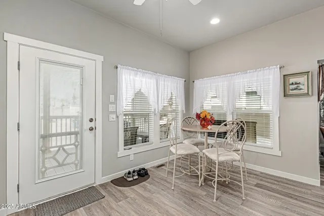 a dining room with furniture a chandelier and wooden floor
